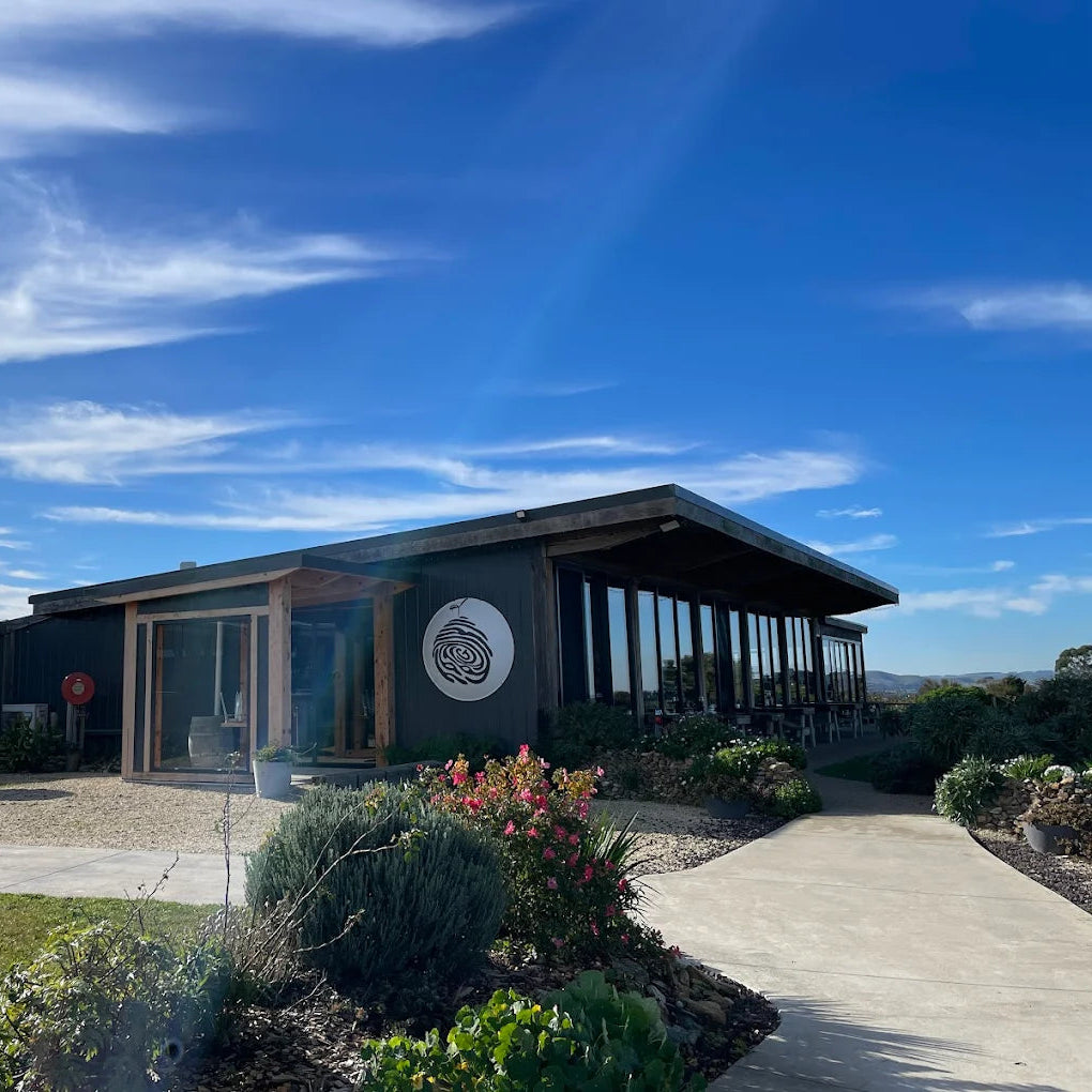 Modern building with a circular logo for Gurneys Cider on a clear day